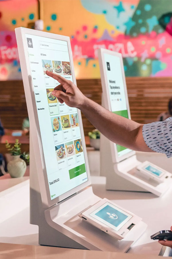 Guests buying admission at a self-serve Clover kiosk